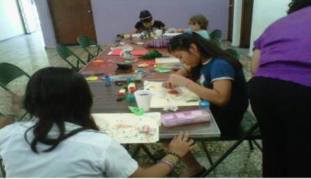 Children and adults working together at tables in a classroom