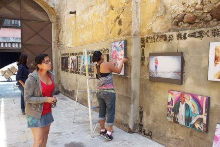 Visitors looking at framed pictures hung on a wall at the museum
