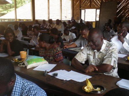 Adults seated at desks writing during a training workshop
