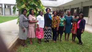 Members of the Ghana project committee standing together on grass outside a school building