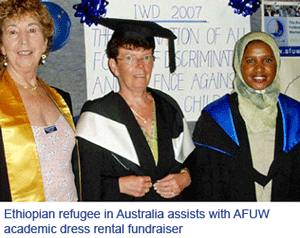 Three women standing in academic gowns and mortarboards in front of an International Women's Day 2007 banner. The caption printed on the photograph reads: Ethiopian refugee in Australia assists with AFUW academic dress rental fundraiser.